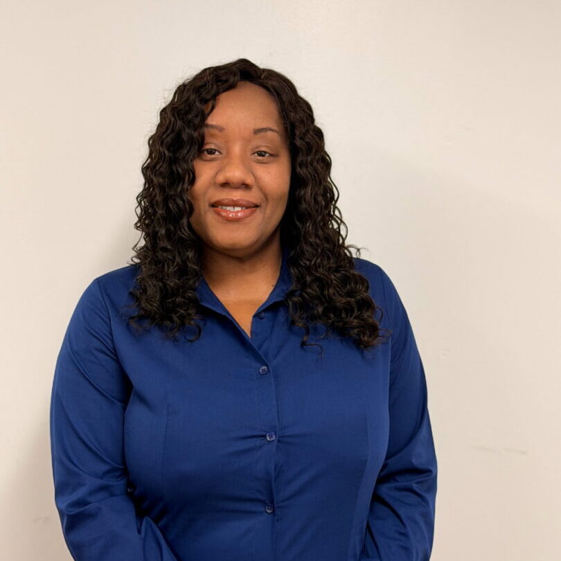 Smiling woman in blue blouse against white background