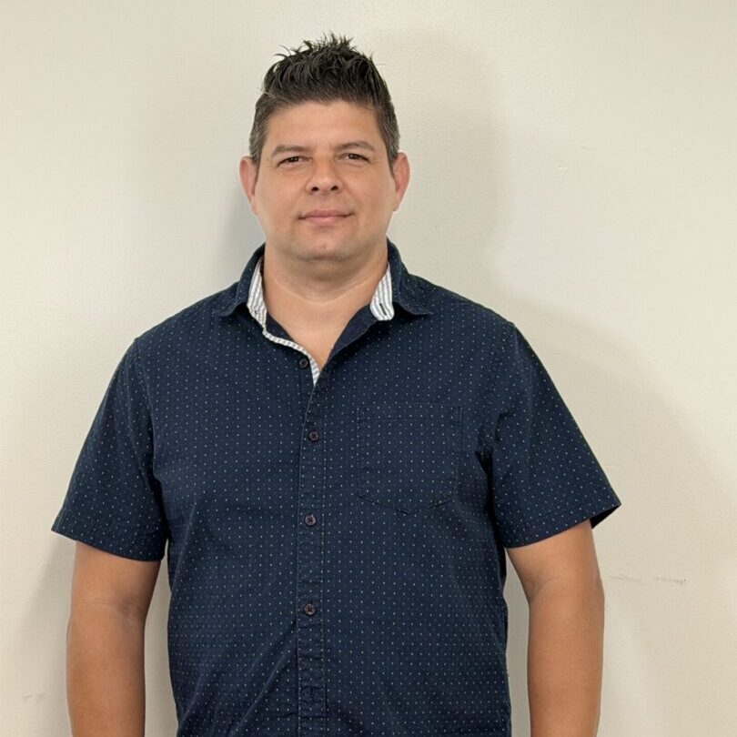 Smiling man standing against plain white wall